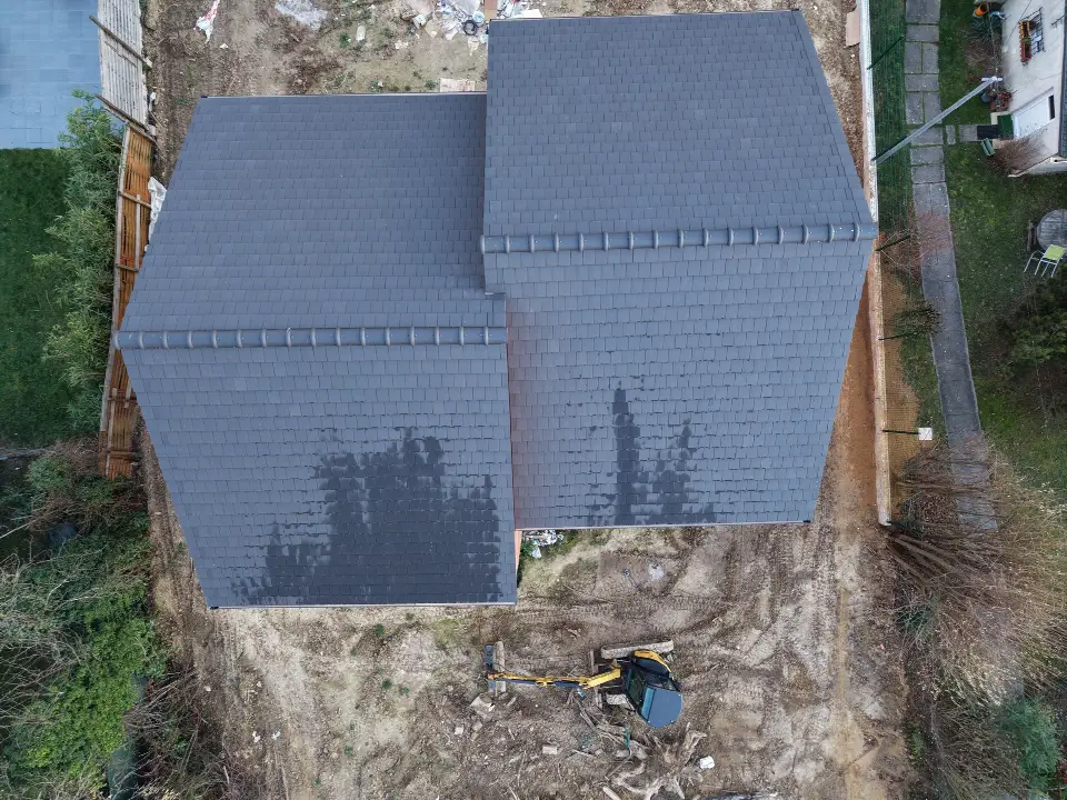 Vue aérienne d'une toiture neuve à plusieurs versants, couverte de tuiles plates anthracite